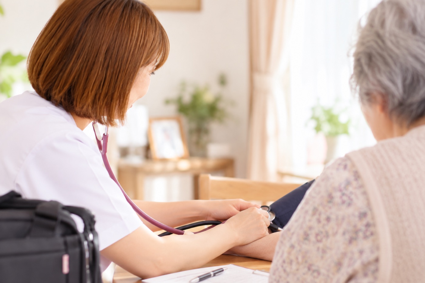 看護師が利用者さんの血圧を測っている様子
